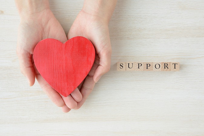 サポートの文字とハートを持つ手